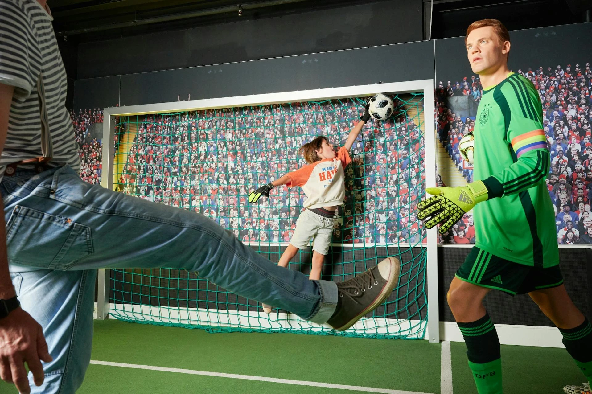 Madame Tussauds Berlin - Kind fängt ein Fußball im Tor, während Manuel Neuer neben ihm steht