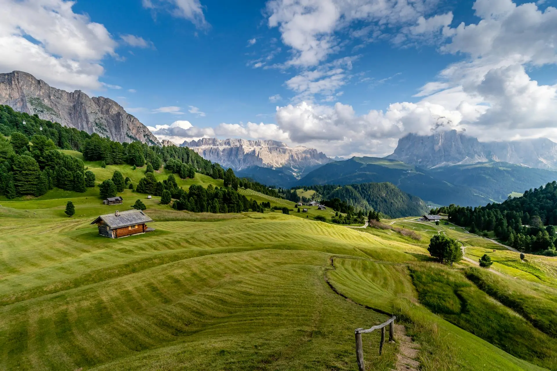 Grüne Wiesen und vereinzelte Berghütten in Trentino-Südtirol