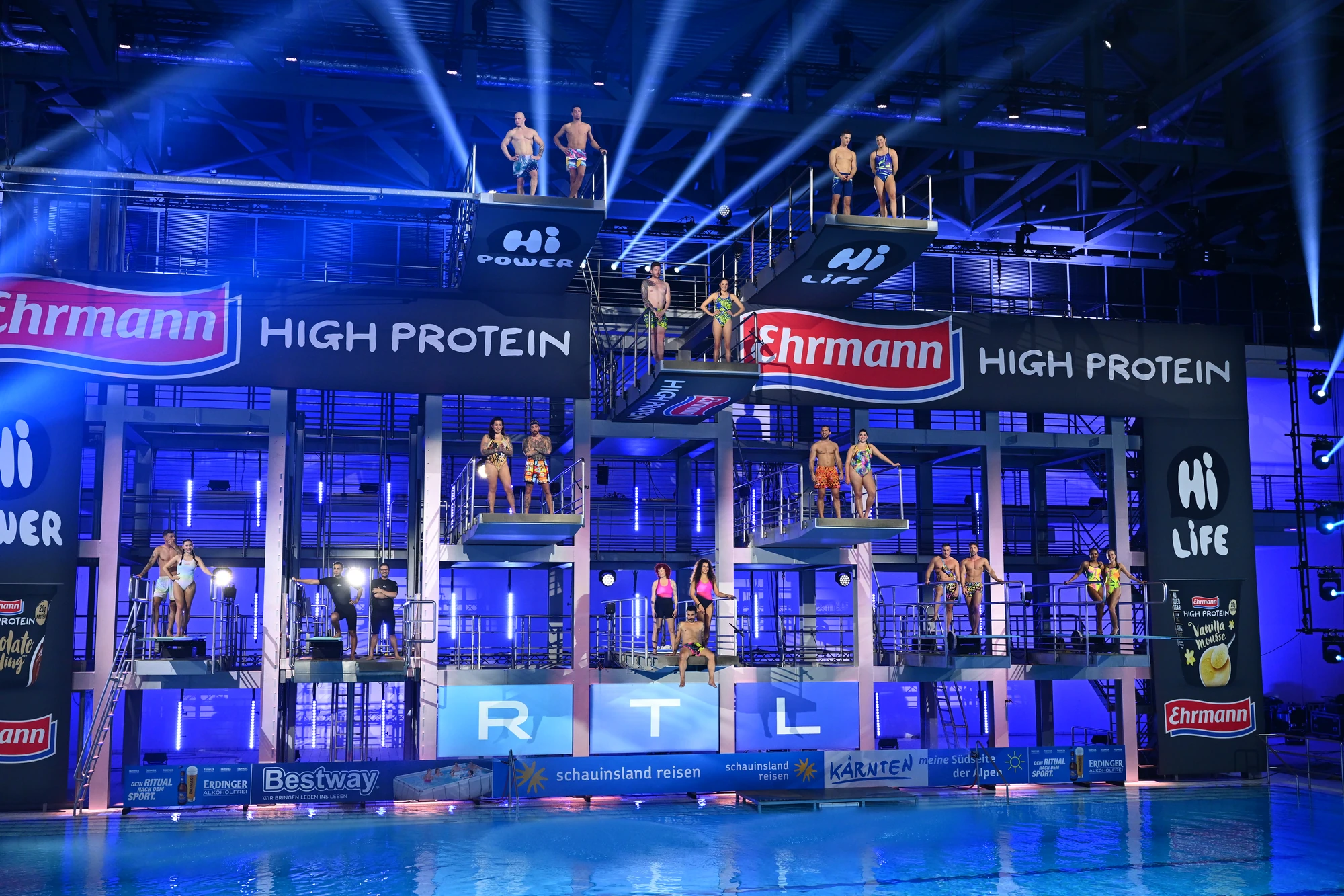 Teilnehmer beim Hochsprung-Event von Ehrmann mit bunten Lichtern und Werbebannern.