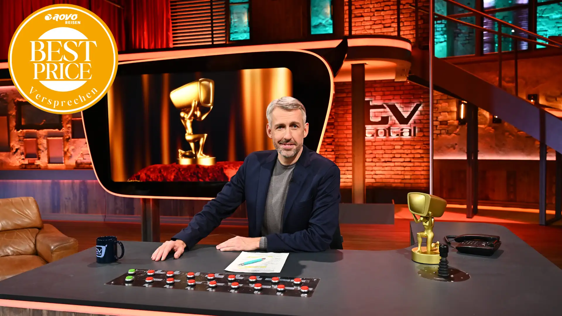 TV total Studio mit Sebastian Pufpaff am Moderatorenpult mit aovo Best Price Logo