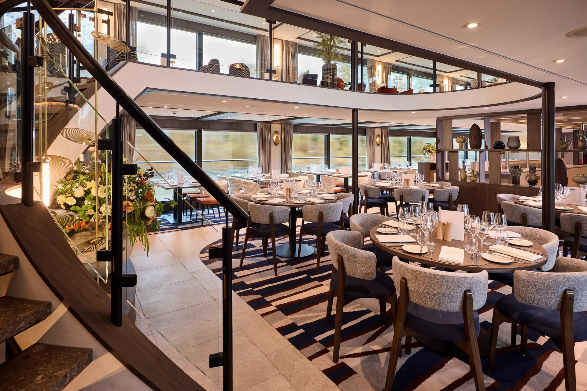 RIVERSIDE Restaurant auf der VIVA ENJOY, gedeckte Tische sowie Treppe zur oberen Etage des Restaurants