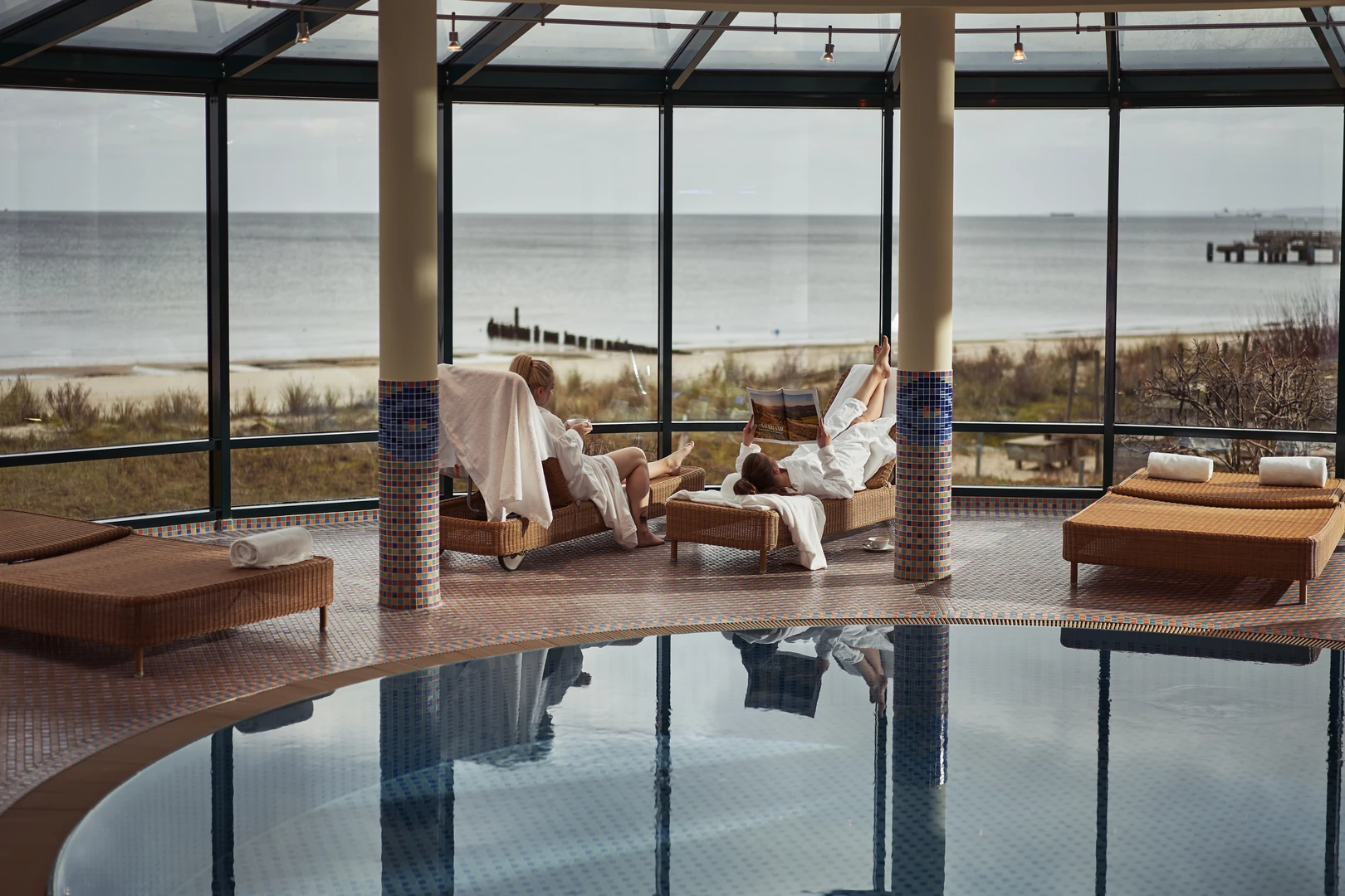 Entspannen mit Meerblick: Im aja Strandhotel Bansin genießen Gäste pure Erholung auf bequemen Liegen im lichtdurchfluteten Wellnessbereich. Der direkte Blick auf die Ostsee und den feinsandigen Strand schafft eine einzigartige Atmosphäre der Ruhe und Gelassenheit.