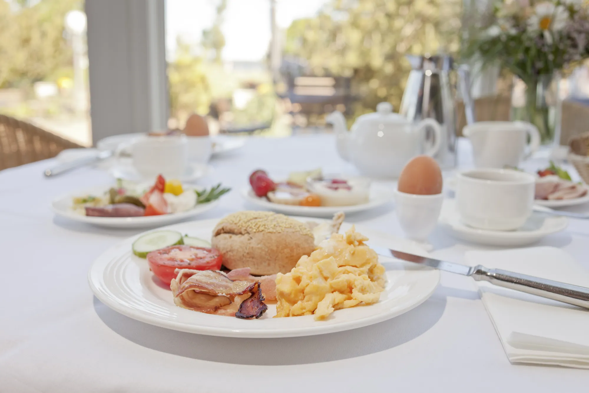 Wellnesshotel Rügen im Aedenlife Hotel & Resort - Blick auf den Frühstückstisch mit Brötchen, Speck und Ei